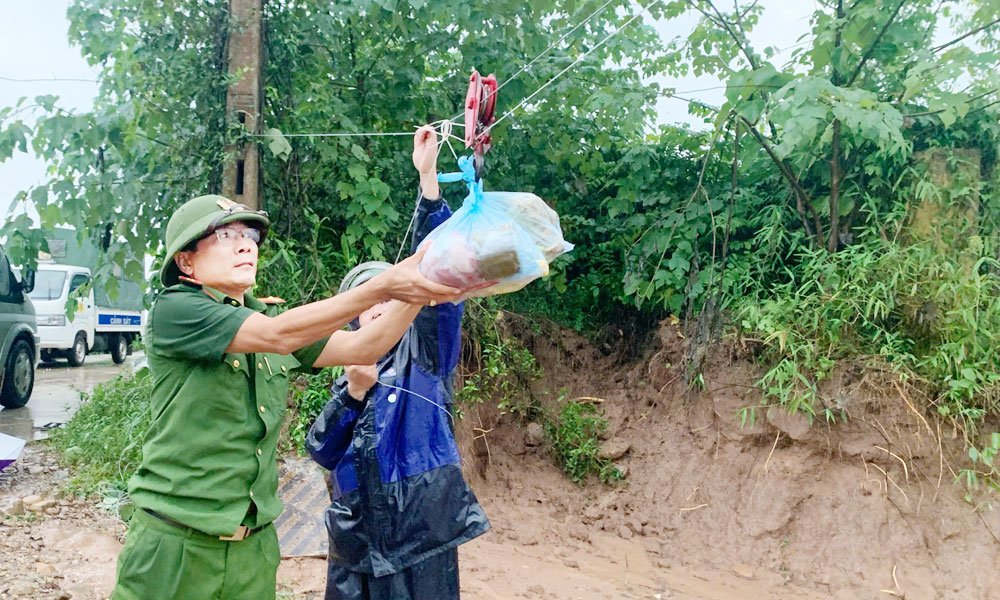 C&ocirc;ng an x&atilde; Đại Sơn phối hợp với lực lượng xung k&iacute;ch ph&ograve;ng, chống thi&ecirc;n tai địa phương vận chuyển nhu yếu phẩm bằng r&ograve;ng rọc.
