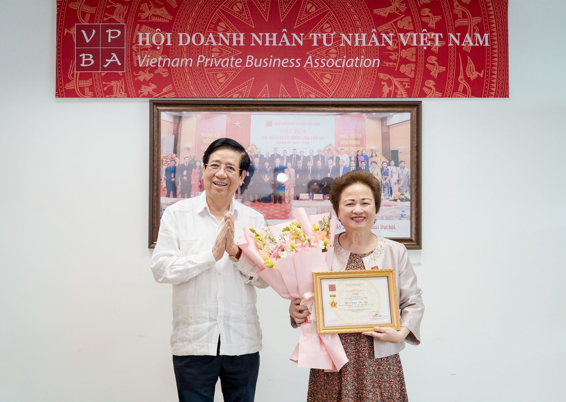 PGS.TS Nguyễn Trọng Điều trao kỷ niệm chương v&agrave; hoa tặng b&agrave; Nguyễn Thị Nga