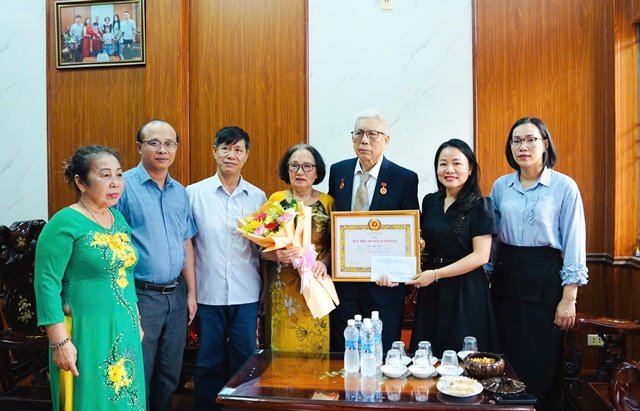 Ph&oacute; B&iacute; thư Đảng uỷ phường Hải V&acirc;n Phạm Thị Hồng Hạnh trao Huy hiệu Đảng 50 năm tuổi Đảng cho Đảng vi&ecirc;n B&ugrave;i Ngọc Ho&aacute;n.