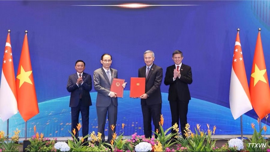 Ủy vi&ecirc;n Bộ Ch&iacute;nh trị, Bộ trưởng Ngoại giao L&ecirc; Ho&agrave;i Trung v&agrave; Bộ trưởng Ngoại giao Singapore Vivian Balakrishnan trao Bản ghi nhớ hợp t&aacute;c giữa hai Đảng. (Ảnh: Phương Hoa/TTXVN)