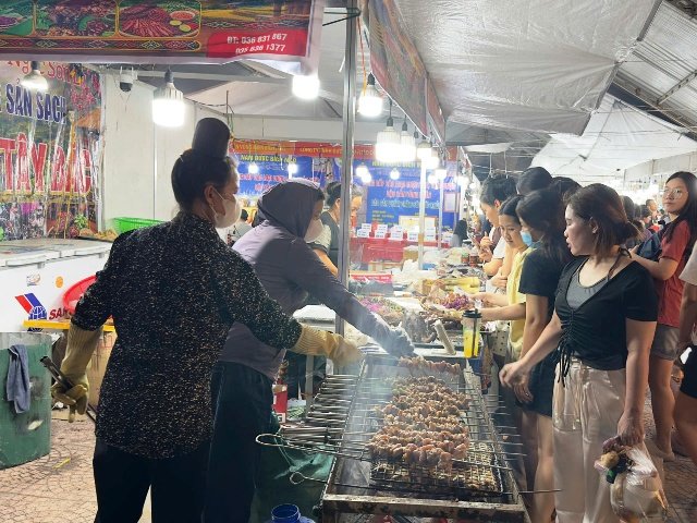 Đ&ocirc;ng đảo người d&acirc;n, thực kh&aacute;ch tham quan c&aacute;c gian h&agrave;ng đặc sản v&ugrave;ng miền.