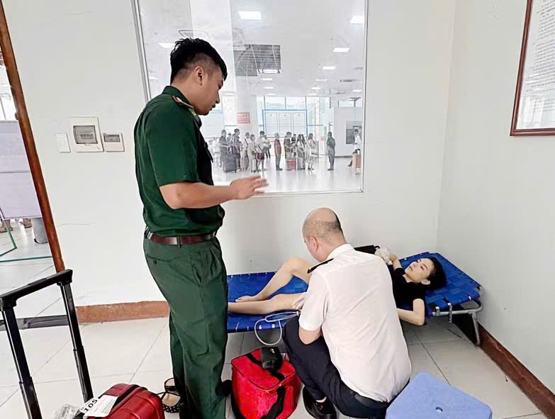 Lực lượng chức năng tại Cửa khẩu quốc tế M&oacute;ng C&aacute;i sơ cứu kịp thời nữ h&agrave;nh kh&aacute;ch bị ngất tại bục xuất cảnh