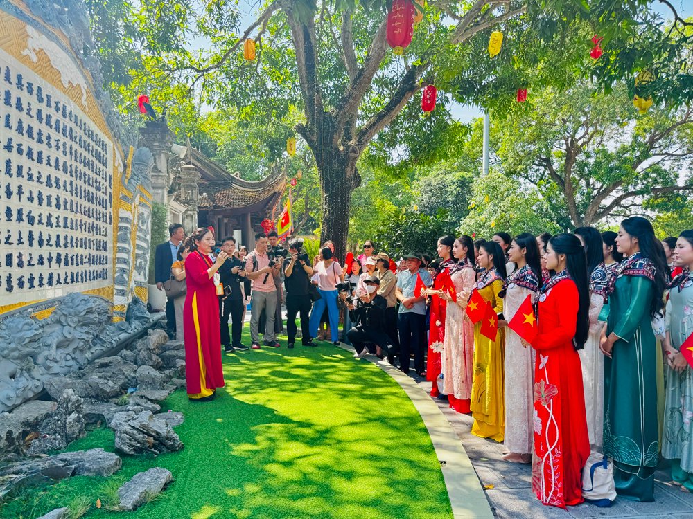 Th&iacute; sinh Hoa hậu Việt Nam 2026 lắng nghe hướng dẫn vi&ecirc;n giới thiệu về lịch sử Đền Đ&ocirc;.
