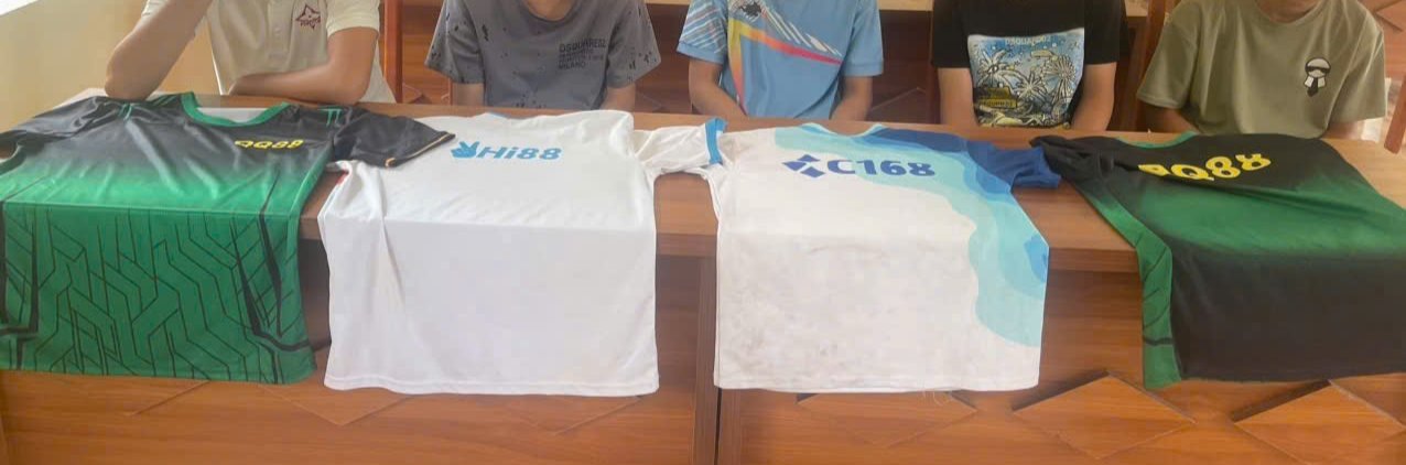 &Aacute;o ph&ocirc;ng c&oacute; in h&igrave;nh logo c&aacute;c trang cờ bạc trực tuyến được c&aacute;c đối tượng t&aacute;n ph&aacute;t cho học sinh dưới dạng qu&agrave; tặng. Ảnh: C&ocirc;ng an cung cấp