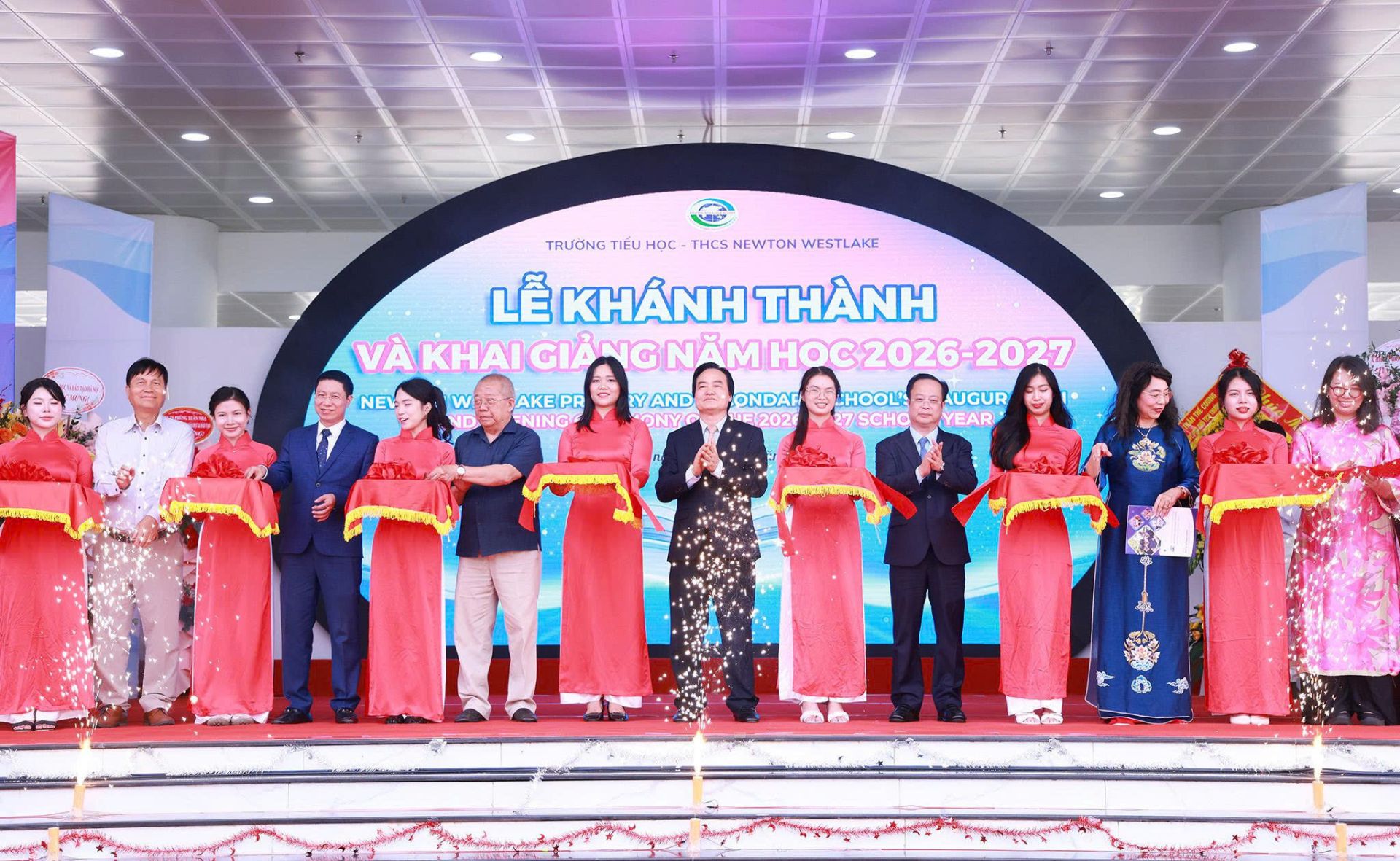 C&aacute;c đại biểu, thầy c&ocirc; thực hiện nghi thức cắt băng kh&aacute;nh th&agrave;nh Trường Tiểu học - THCS Newton Westlake.