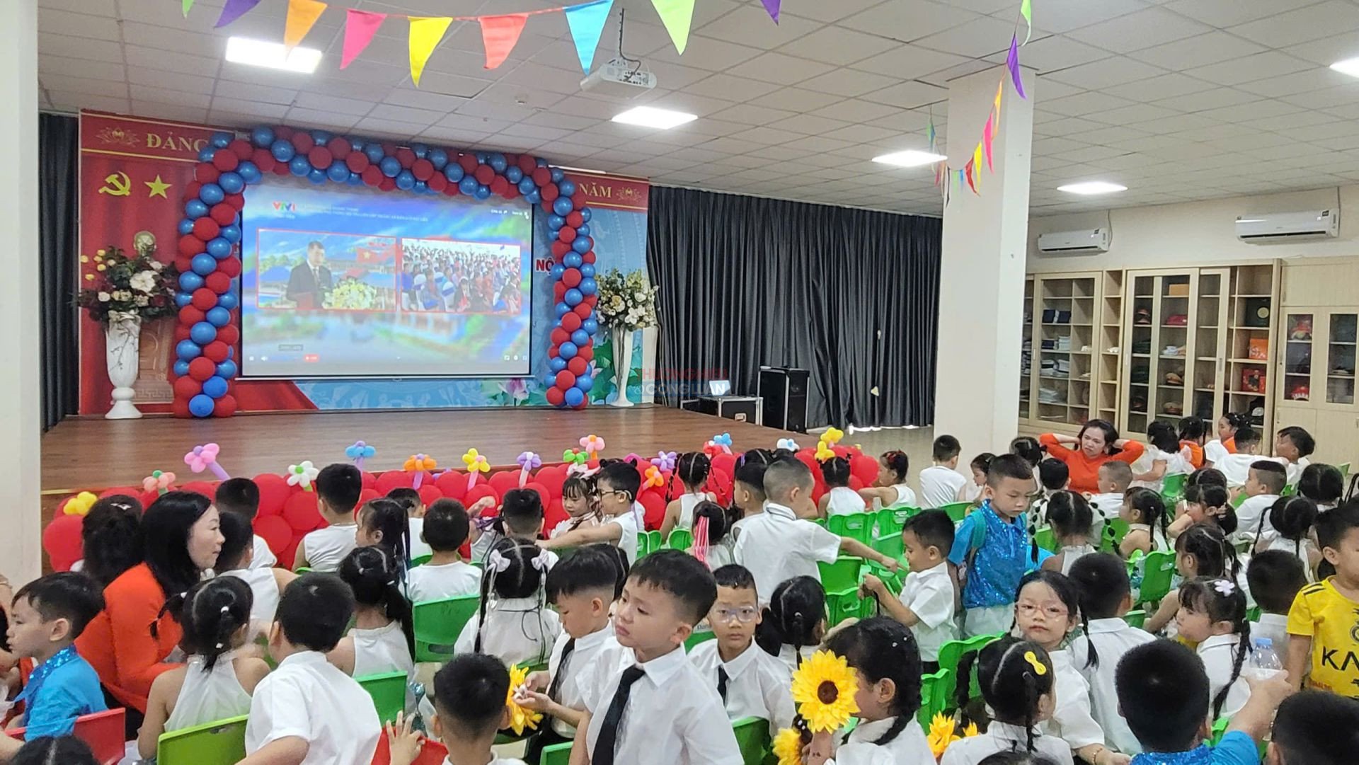 C&aacute;c em học sinh Mầm non L&ocirc;m&ocirc;n&ocirc;xốp Dương Nội tập trung tại hội trường, chăm ch&uacute; theo d&otilde;i h&igrave;nh ảnh Lễ Khai giảng trực tuyến to&agrave;n quốc được ph&aacute;t từ điểm cầu ch&iacute;nh L&agrave;o Cai qua m&agrave;n h&igrave;nh lớn.
