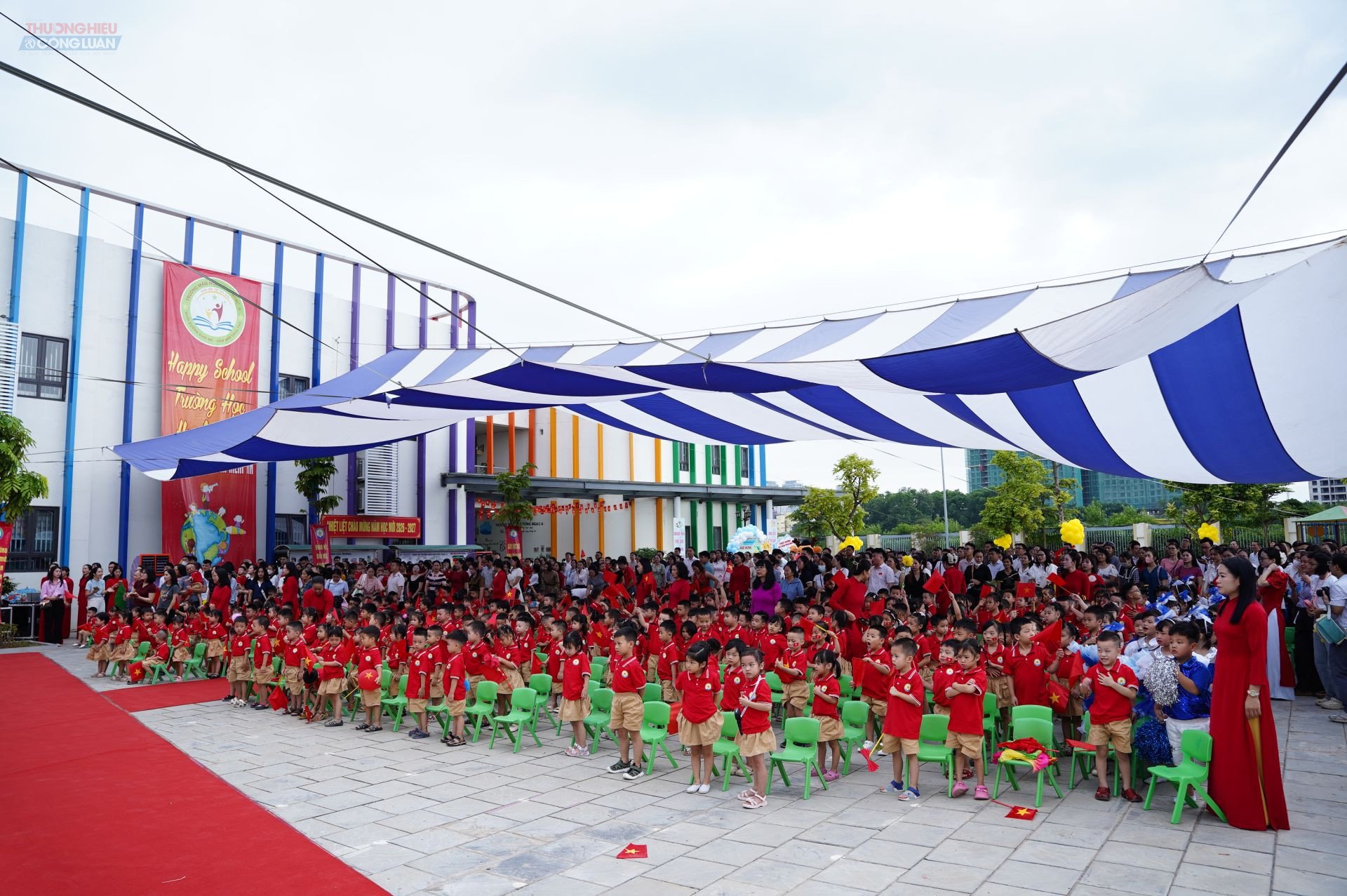 C&aacute;c em nhỏ c&ugrave;ng c&aacute;c vị đại biểu, thầy c&ocirc; gi&aacute;o v&agrave; c&aacute;c bậc phụ huynh đứng dậy l&agrave;m lễ Ch&agrave;o cờ