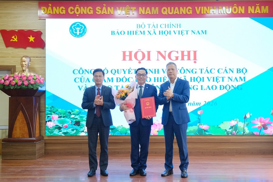 Ph&oacute; Gi&aacute;m đốc BHXH Việt Nam Trần Đ&igrave;nh Liệu v&agrave; Ph&oacute; Chủ tịch UBND tỉnh Đinh Văn Tuấn trao quyết định v&agrave; tặng hoa ch&uacute;c mừng đồng ch&iacute; V&otilde; Kh&aacute;nh B&igrave;nh &ndash; Ph&oacute; Gi&aacute;m đốc BHXH tỉnh L&acirc;m Đồng.