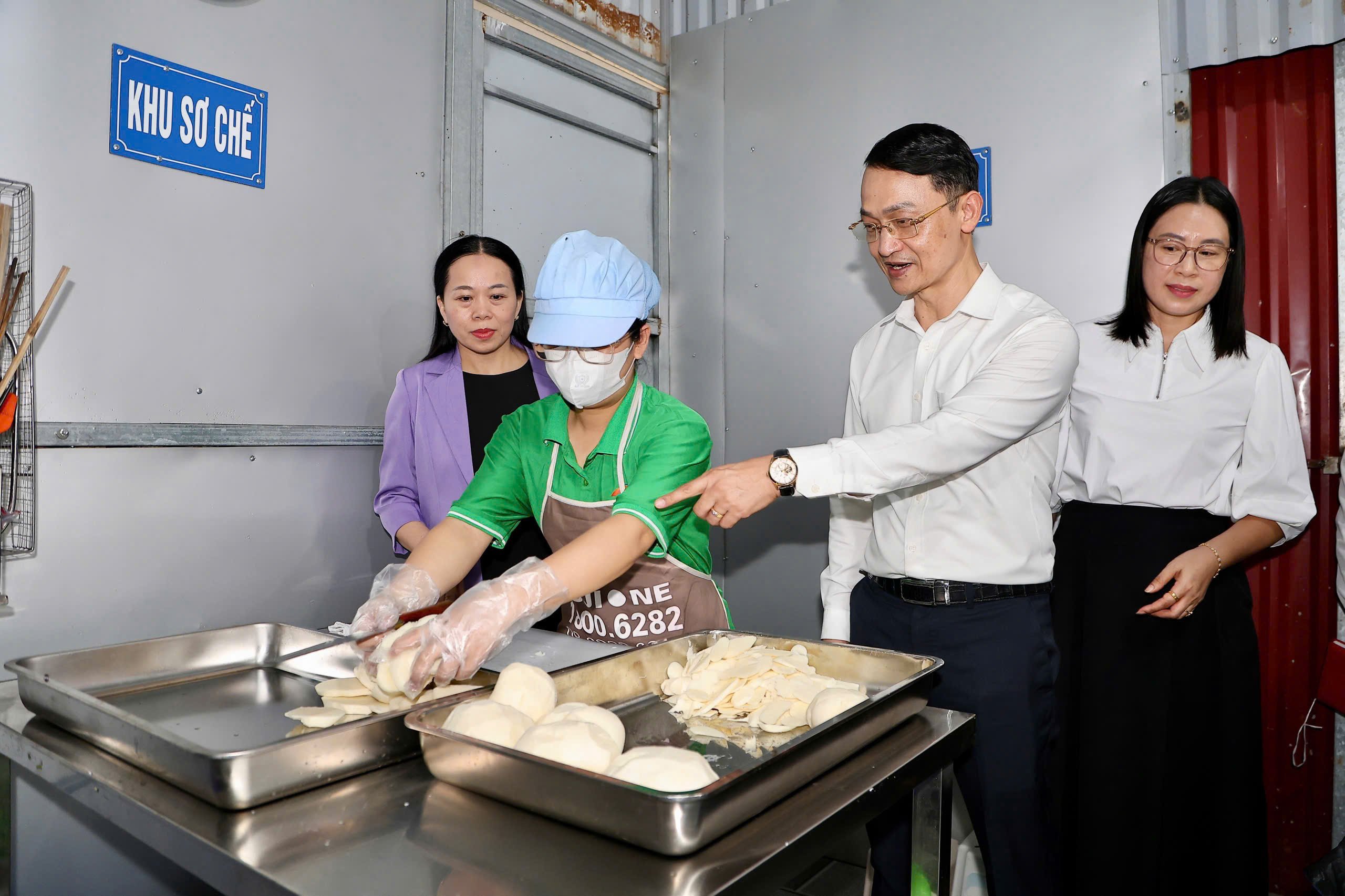 Đo&agrave;n gi&aacute;m s&aacute;t kiểm tra khu vực nấu ăn b&aacute;n tr&uacute; cho học sinh.