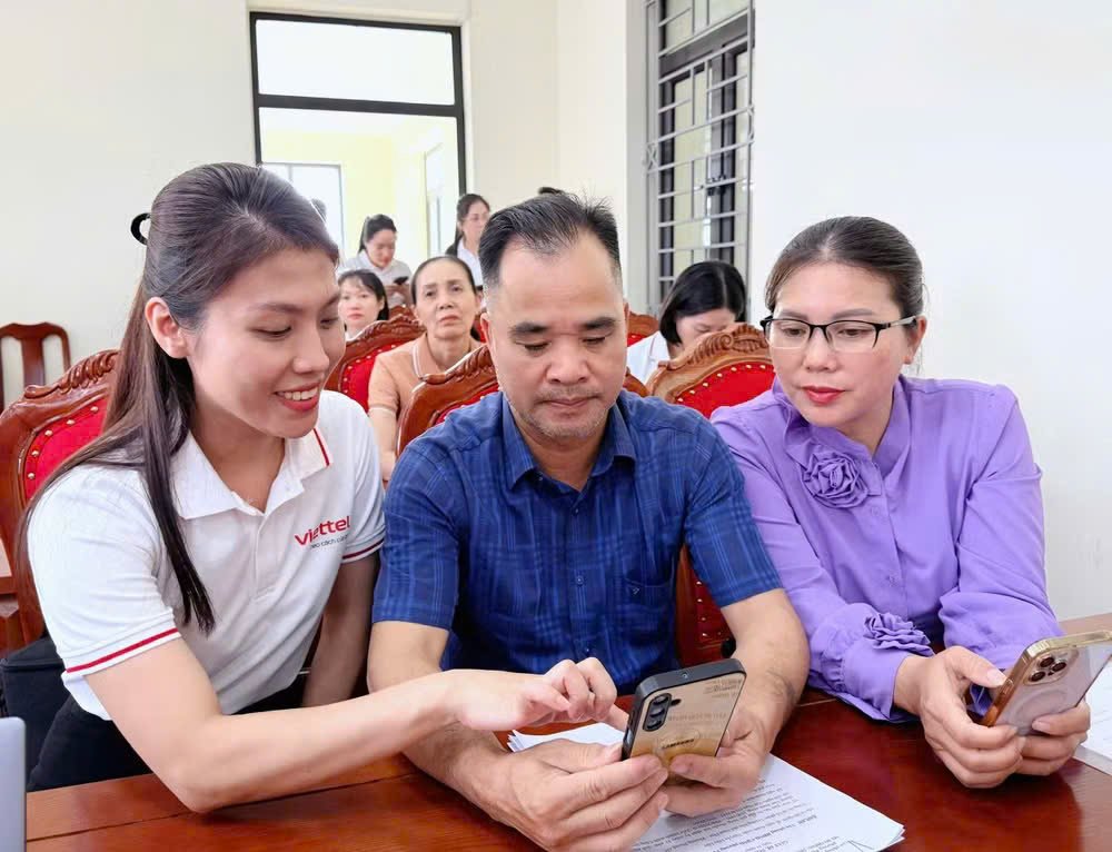 Nh&acirc;n vi&ecirc;n Viettel Quảng Ninh hướng dẫn người d&acirc;n phường Phong Cốc c&aacute;c tiện &iacute;ch của ứng dụng Tammi OA trong buổi lễ ra mắt m&ocirc; h&igrave;nh