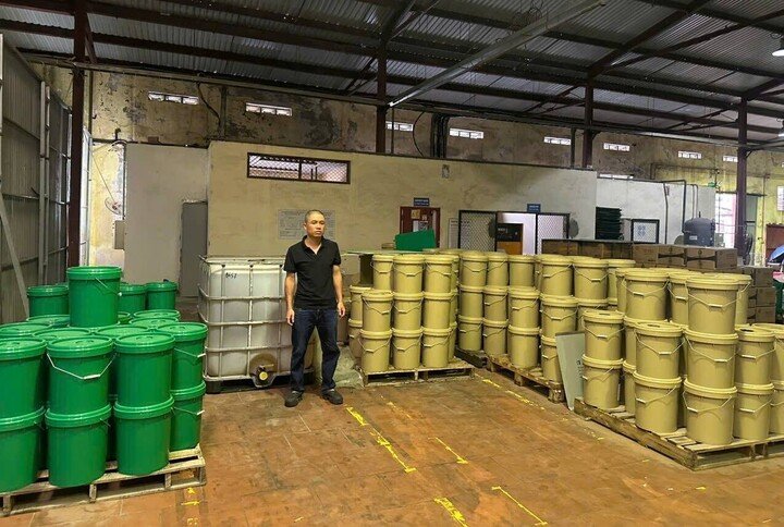 Đối tượng Đo&agrave;n Ngọc Cảnh v&agrave; tang vật l&agrave; l&ocirc; dầu nhờn JP Mitsu HD50 vi phạm. Ảnh: C&ocirc;ng an cung cấp