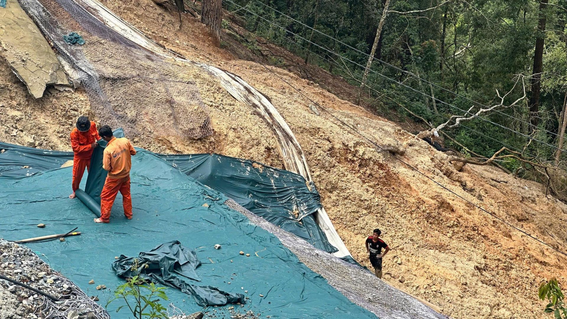 như bạt phủ, lưới chắn ngăn đất đ&aacute; tiếp tục tr&agrave;n xuống l&ograve;ng đường trước khi triển khai g&oacute;i gia cố l&acirc;u d&agrave;i.