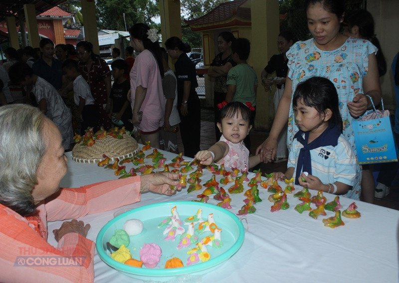 Các bé thích thú với những con vật dễ thương được nặn từ bột do chính người dân Long Sơn thực hiện Các bé thích thú với những con vật dễ thương được nặn từ bột do chính người dân Long Sơn thực hiện