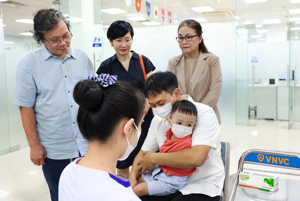 B&aacute;c sĩ Trương Hữu Khanh, người c&oacute; h&agrave;ng chục năm gắn b&oacute; với c&ocirc;ng t&aacute;c điều trị c&aacute;c ca tay ch&acirc;n miệng nặng tại Việt Nam, chứng kiến em b&eacute; đầu ti&ecirc;n tại Việt Nam ti&ecirc;m vắc xin ph&ograve;ng tay ch&acirc;n miệng tại VNVC. Ảnh: Nh&acirc;n L&ecirc;