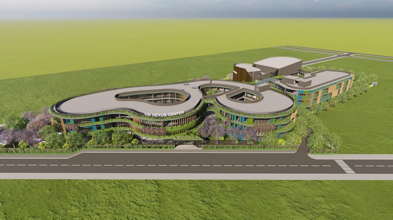Từ tr&ecirc;n cao nh&igrave;n xuống, Vin Nexus Center mang h&igrave;nh d&aacute;ng một tr&aacute;i tim xanh, được tạo n&ecirc;n bởi những đường cong mềm mại thay v&igrave; c&aacute;c g&oacute;c cạnh. Nhưng đi s&acirc;u v&agrave;o b&ecirc;n trong, c&oacute; thể nhận ra h&igrave;nh tr&aacute;i tim ấy kh&ocirc;ng chỉ nằm ở kiến tr&uacute;c. N&oacute; nằm trong c&aacute;ch từng khoảng mở, lớp học, g&oacute;c nghỉ, khu vận động hay kh&ocirc;ng gian m&ocirc; phỏng đời sống đều được bắt đầu từ một c&acirc;u hỏi giản dị: &ldquo;Kh&ocirc;ng gian n&agrave;y sẽ gi&uacute;p một đứa trẻ cảm thấy thế n&agrave;o, v&agrave; c&oacute; thể l&agrave;m được g&igrave; khi ở đ&acirc;y?&rdquo;. (Ảnh thiết kế to&agrave;n cảnh của trường).