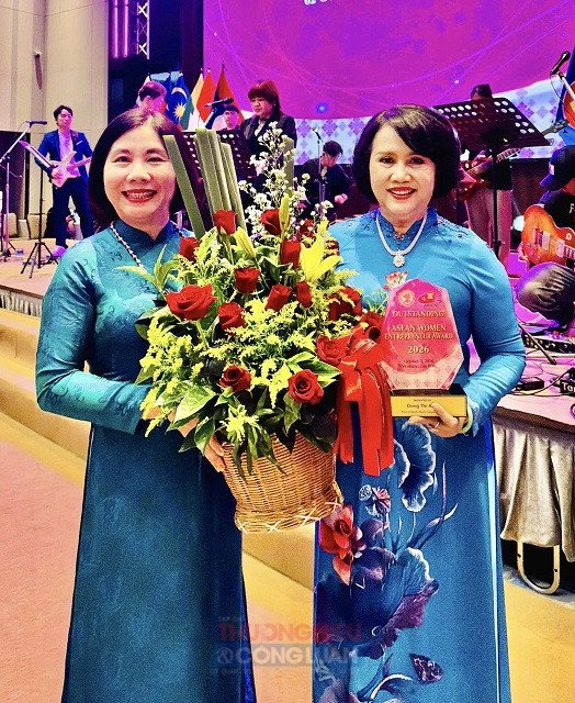 B&agrave; Trần Thị T&uacute; Anh (b&ecirc;n tr&aacute;i) tặng hoa ch&uacute;c mừng nữ doanh nh&acirc;n Đồng Thị &Aacute;nh. Ảnh: L&acirc;m Vy