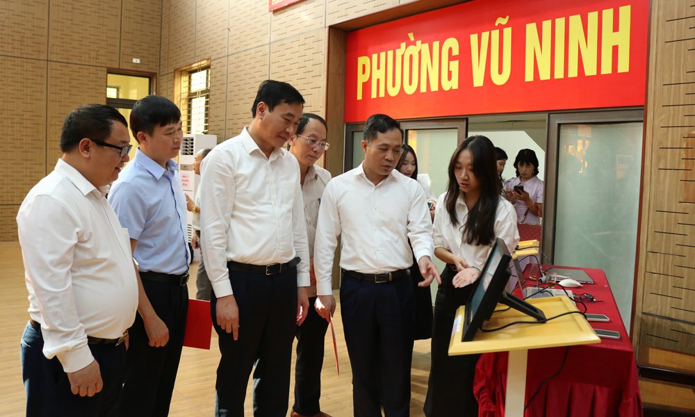 L&atilde;nh đạo phường Vũ Ninh c&ugrave;ng c&aacute;c đại biểu nghe thuyết minh về nền tảng Cổng kinh tế số.