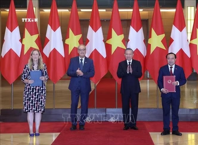 Tổng B&iacute; thư, Chủ tịch nước T&ocirc; L&acirc;m v&agrave; Tổng thống Thụy Sĩ Guy Parmelin chứng kiến lế trao c&aacute;c văn kiện hợp t&aacute;c giữa hai nước. Ảnh: Thống Nhất/TTXVN