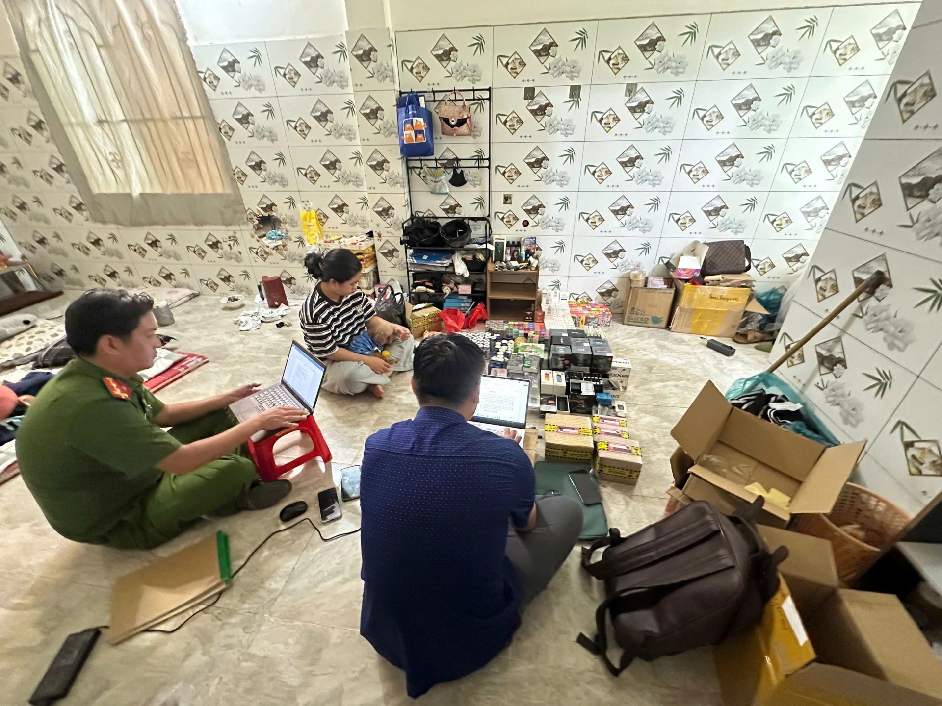 Lực lượng chức năng kiểm tra, lập bi&ecirc;n bản số h&agrave;ng h&oacute;a vi phạm tại cơ sở kinh doanh. Ảnh: C&ocirc;ng an Vĩnh Long