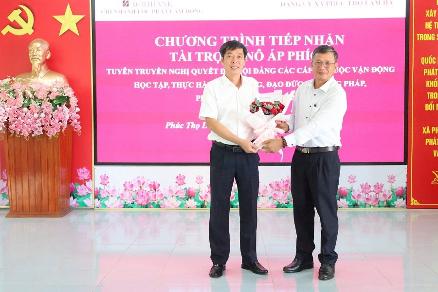 &Ocirc;ng Đ&agrave;o Đức Oai (b&ecirc;n phải)&ndash; B&iacute; thư Đảng ủy, Chủ tịch HĐND x&atilde; tặng hoa cảm ơn đại diện Agribank Chi nh&aacute;nh Lộc Ph&aacute;t L&acirc;m Đồng v&igrave; sự quan t&acirc;m, hỗ trợ c&ocirc;ng t&aacute;c tuy&ecirc;n truyền tại địa phương.