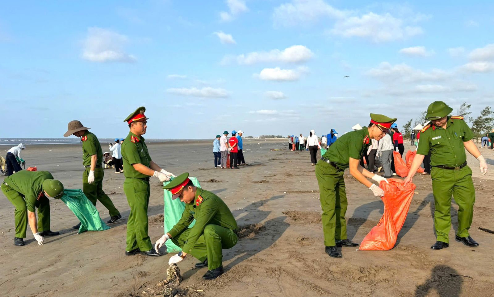 C&aacute;n bộ, chiến sĩ C&ocirc;ng an x&atilde; Giao Ninh tham gia thu gom r&aacute;c thải, l&agrave;m sạch m&ocirc;i trường tại khu vực b&atilde;i biển Quất L&acirc;m